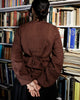 Rear view of cotton dobby shirt showing back waist tie for adjustable fit, worn in a vintage library.