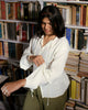 Ivory white vintage-inspired cotton blouse styled with olive trousers, featuring back tie and asymmetrical buttons