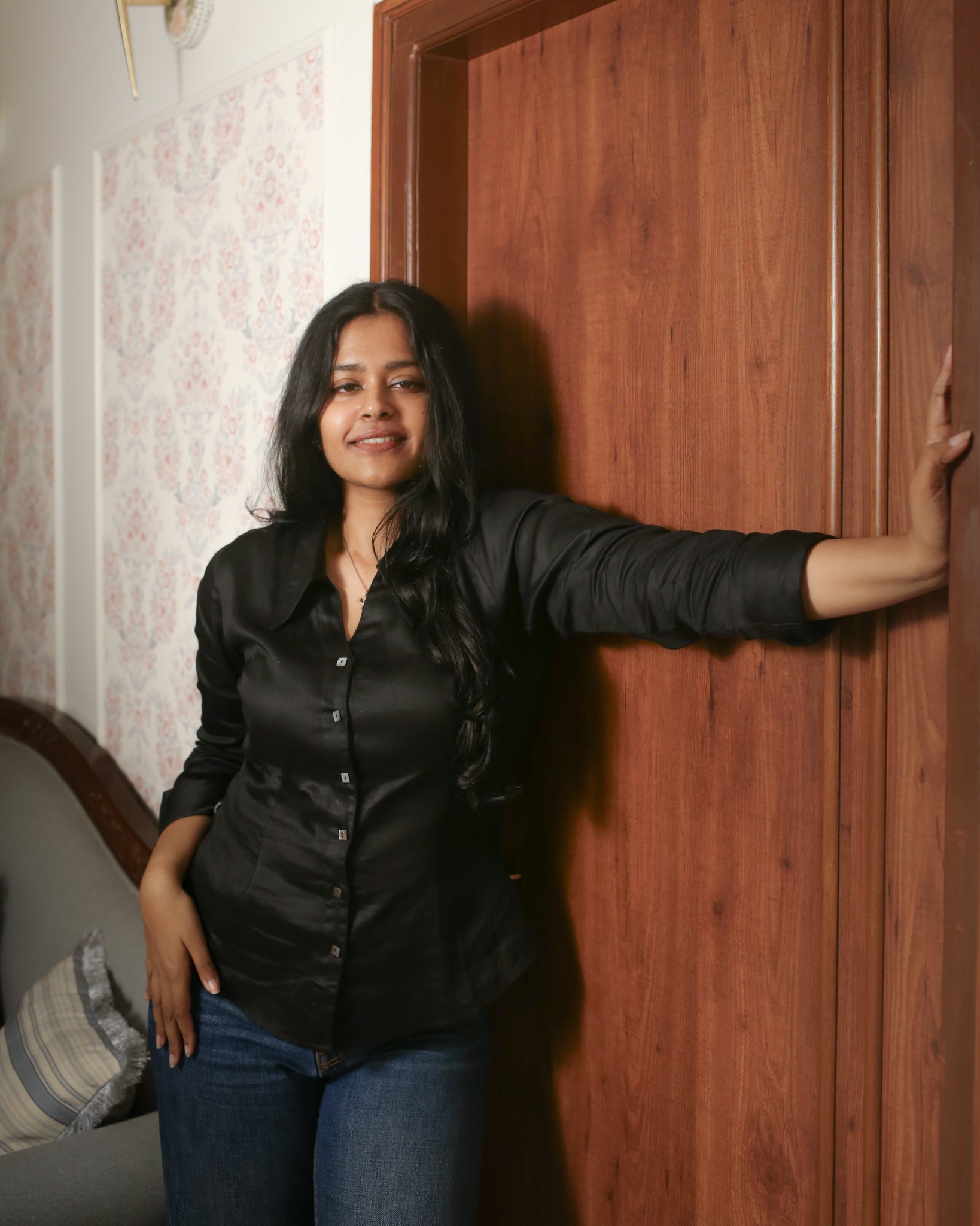 Black fitted shirt in satin cotton fabric, shown from side with emphasis on waist darts and curve-friendly hem