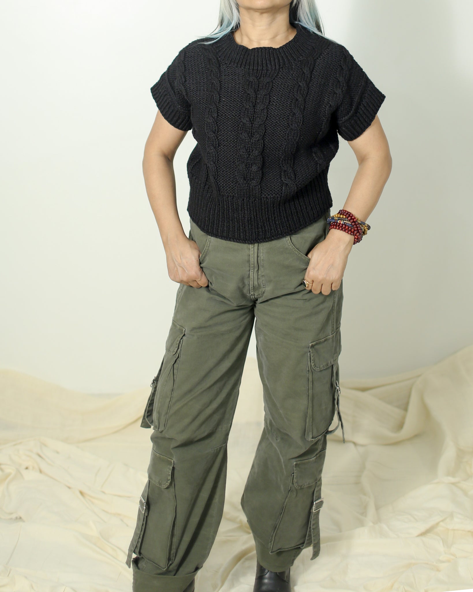 Model styling a black wool sweater in 100% pure wool with cargo for a casual winter look.