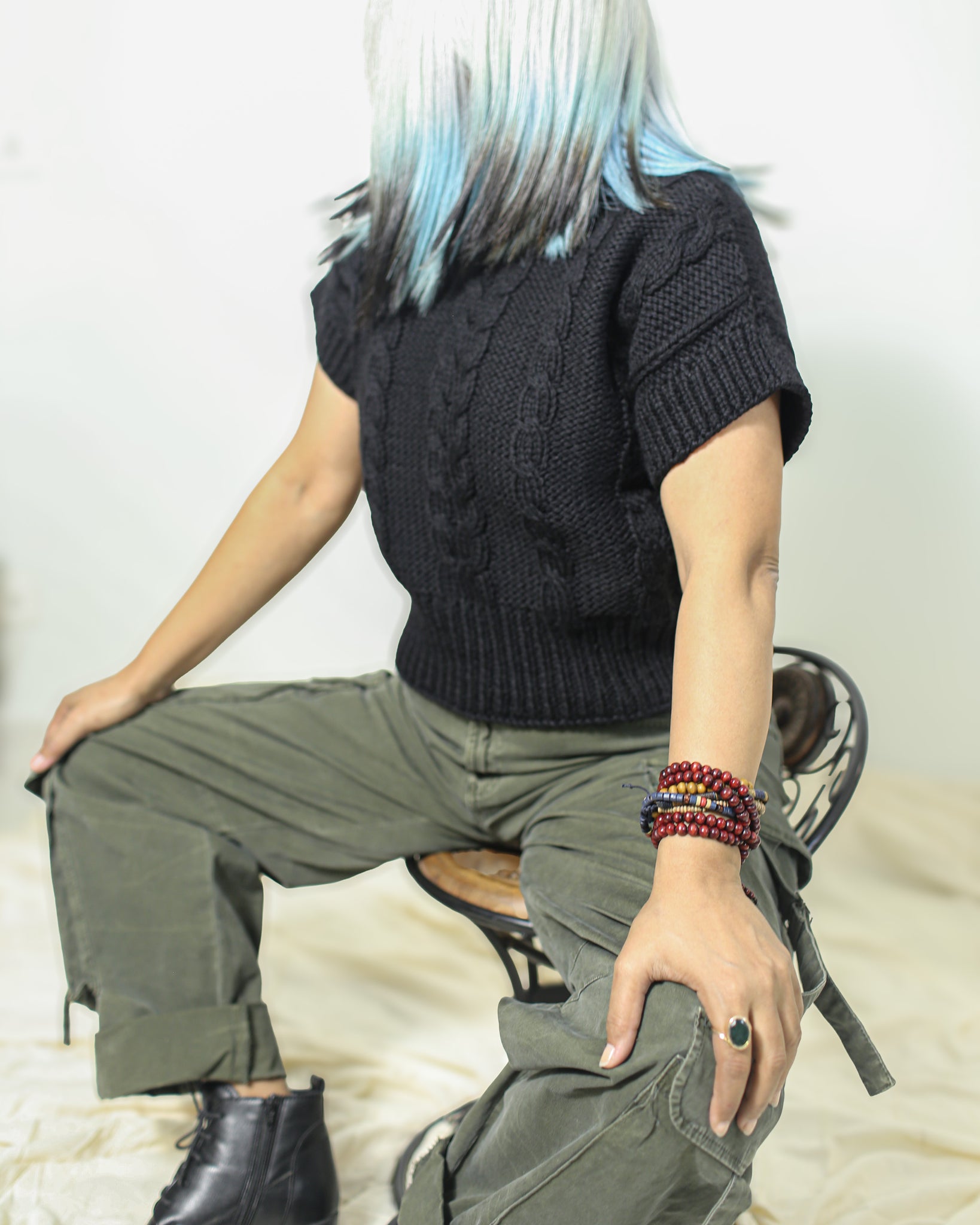 Side view of a black wool sweater in 100% pure wool with armhole border for a structured fit.