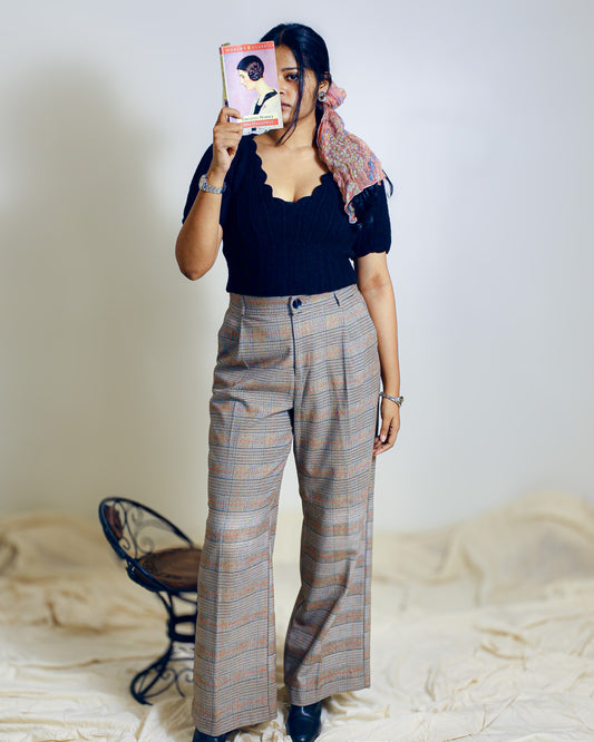 black scallop neck sweater styled with high-waisted trousers.
