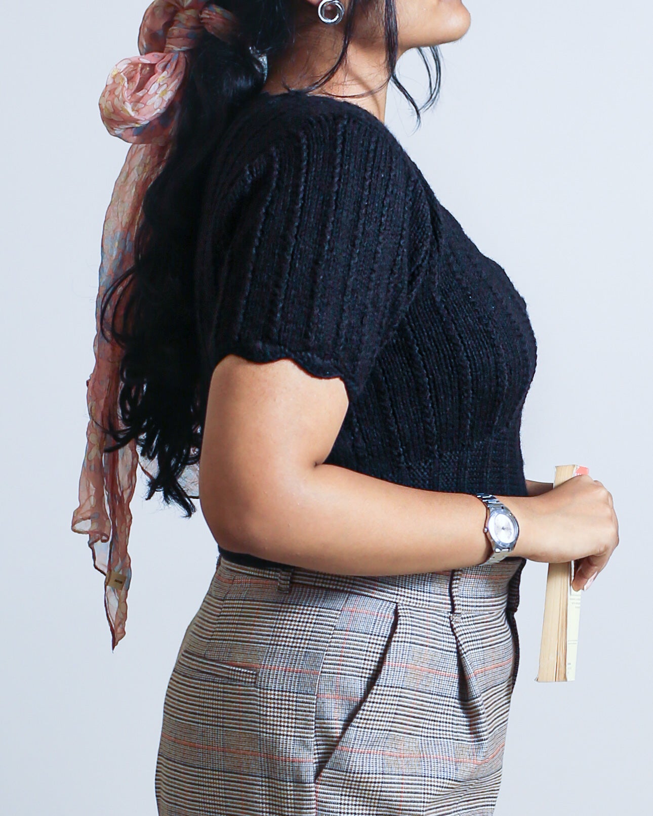 Close-up of the sleeve crocheted-edge detailing on a hand-knitted wool crop sweater in 100% pure wool in black.