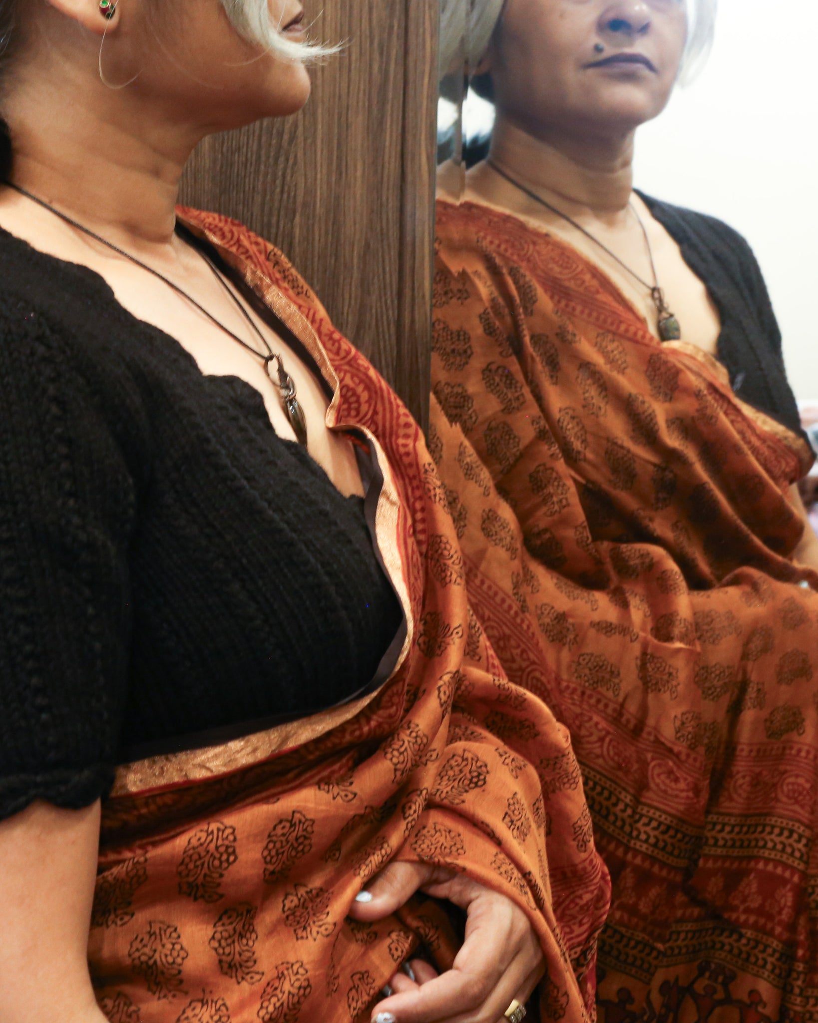 Black wool scallop neck sweater in 100% pure wool styled as a blouse with saree.