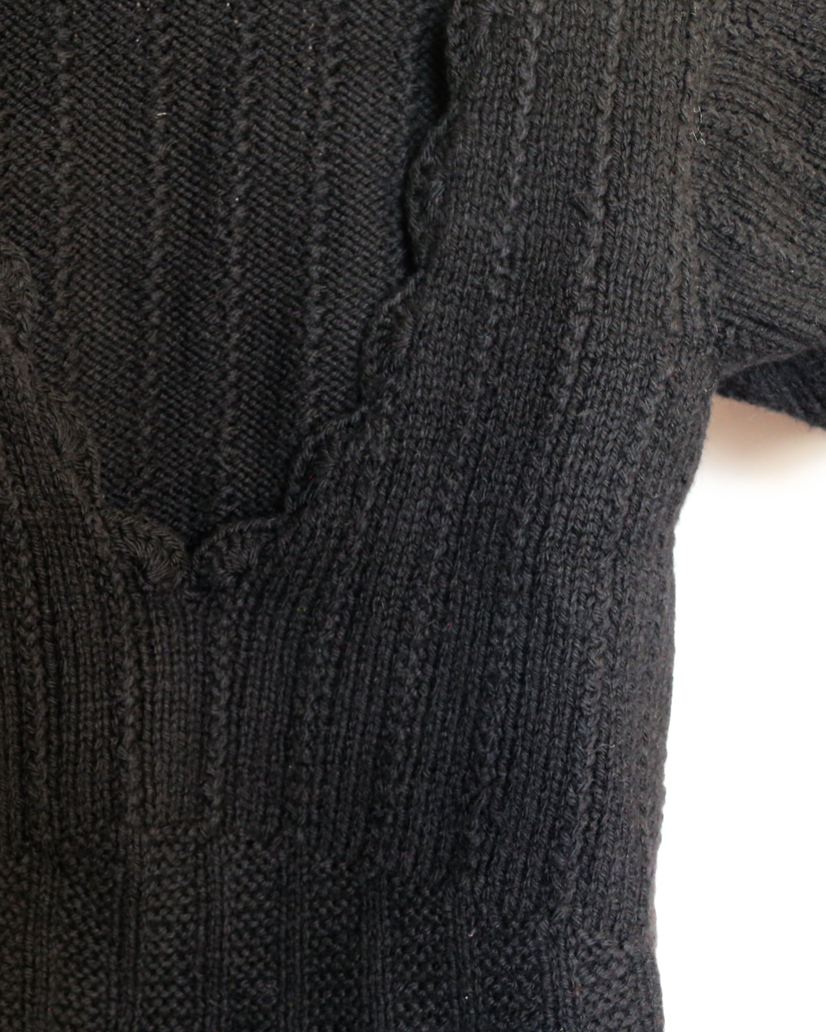 close-up of the knitted sweater having crocheted edges in 100% pure wool.