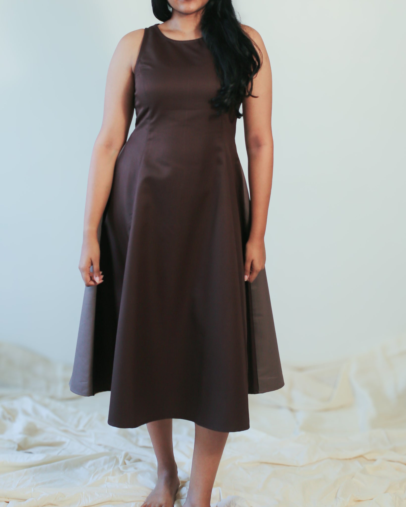 Model wearing a fit & flare midi dress, styled with golden jewellery for a formal look.