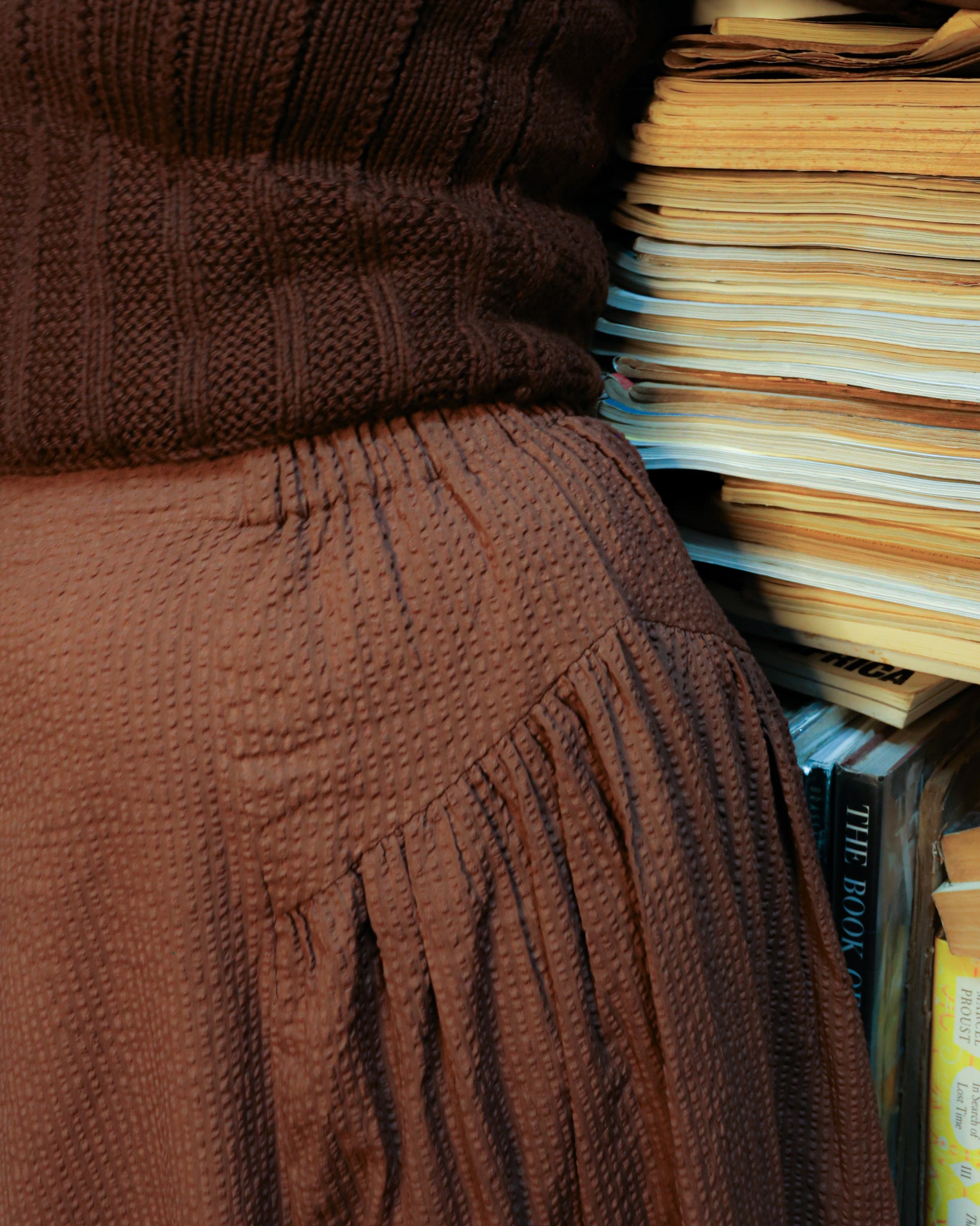 close-up of the side gather panel of midi skirt in brown having elasticated waistband.