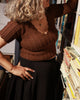 Rustic brown crop sweater made in 100% pure wool showing intricate knit patterns on the bodice and waist.