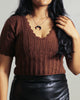 Close-up of the scallop neck detailing on a hand-knitted wool crop sweater made in 100% pure wool in rustic brown paired with leather skirt.