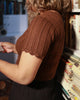 Detailed view of hand-knitted scallop edges on a short-sleeve woolen sweater made in 100% pure wool