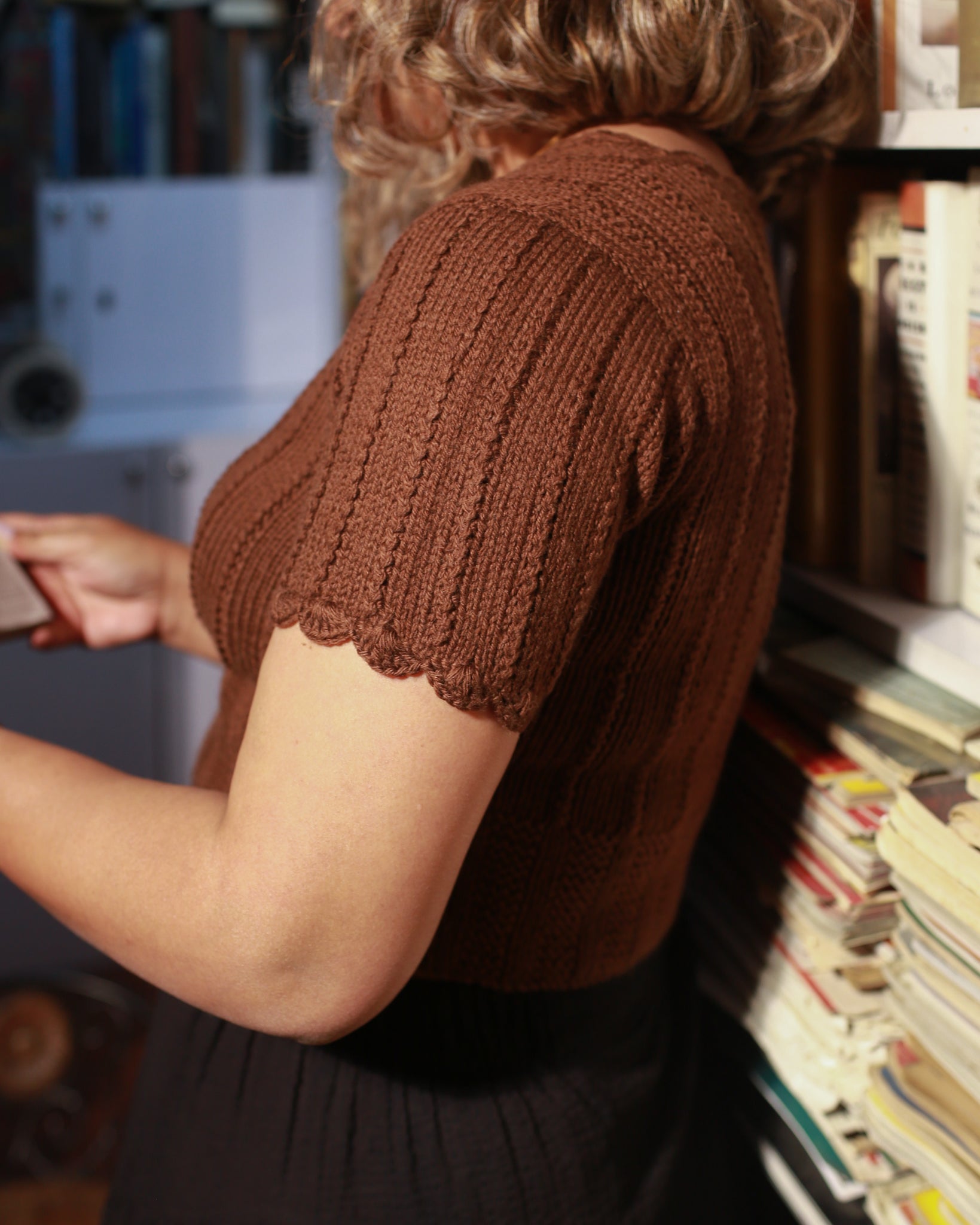 Detailed view of hand-knitted scallop edges on a short-sleeve woolen sweater made in 100% pure wool