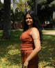 Smiling woman in textured ochre cotton top with elastic waist, ideal for slow fashion wardrobes.
