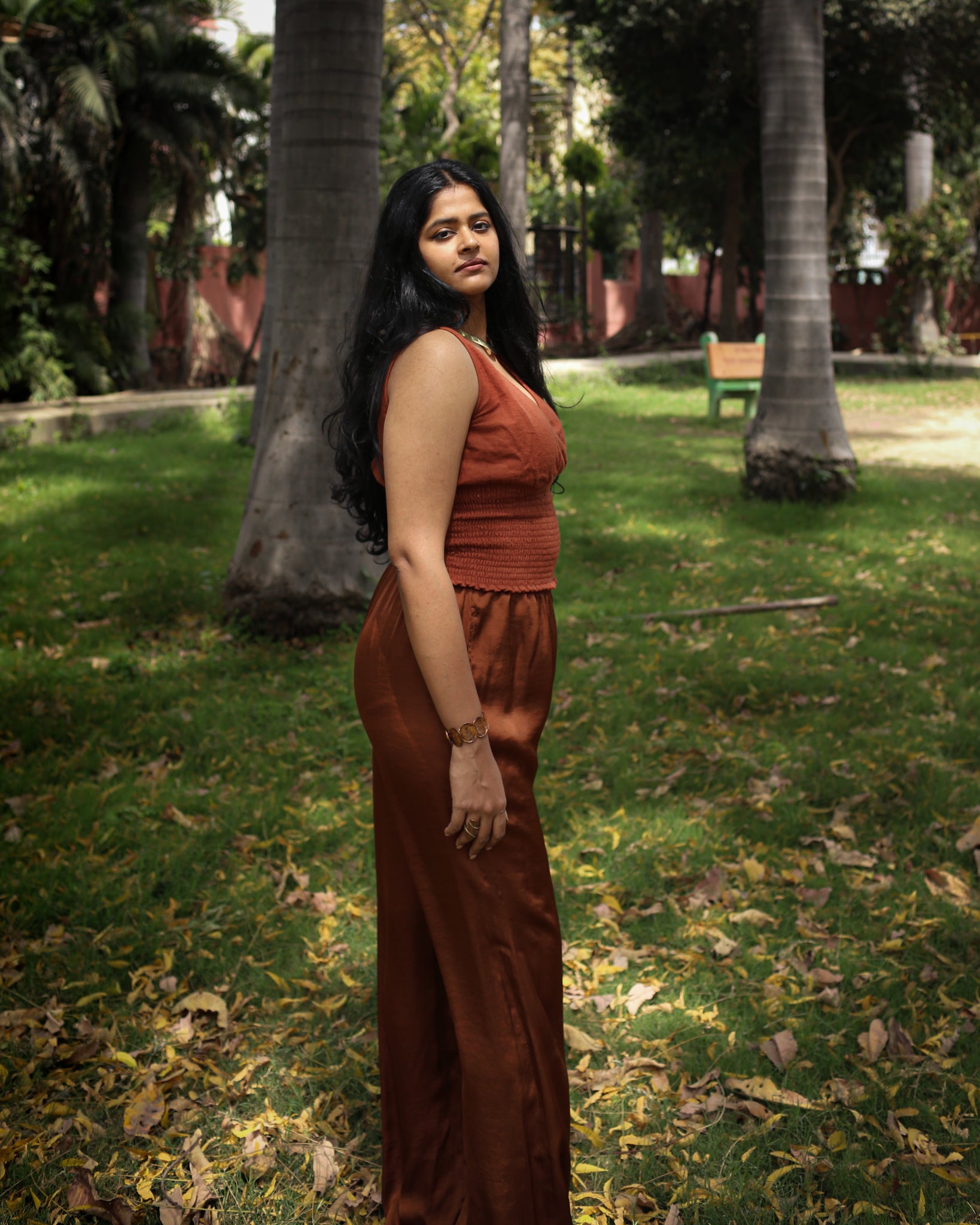 Side profile of fitted cotton top in rust orange, showing overlapping bust detail and sculpted smocking.