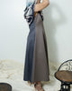 Side view of model wearing a fit & flare midi dress, styled with a scarf.