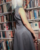Model wearing dual-shade fit & flare midi standing in a library.