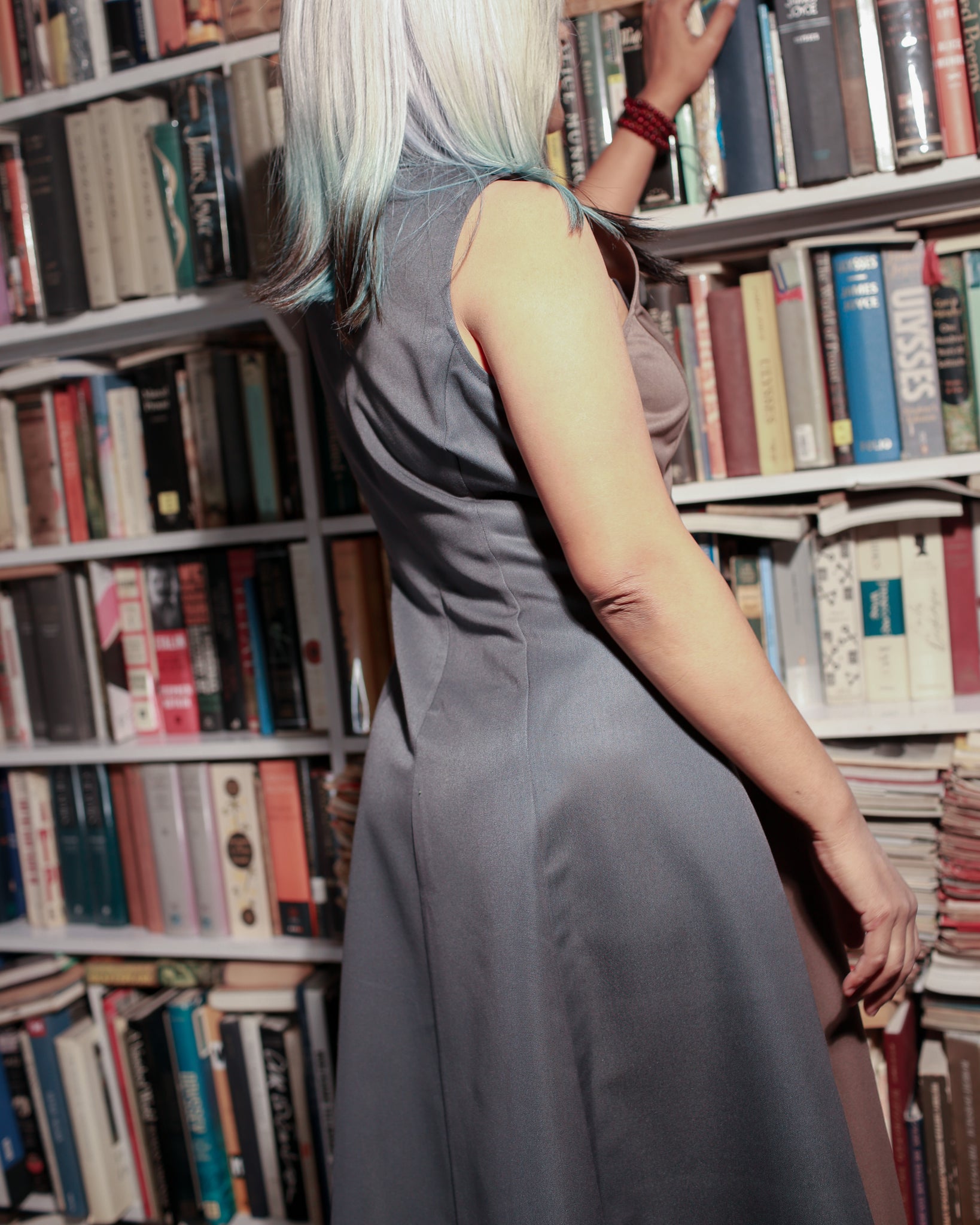 Model wearing dual-shade fit & flare midi standing in a library.
