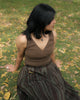 Model standing on lawn in rustic green cotton top with corset-like stretch waist panel.