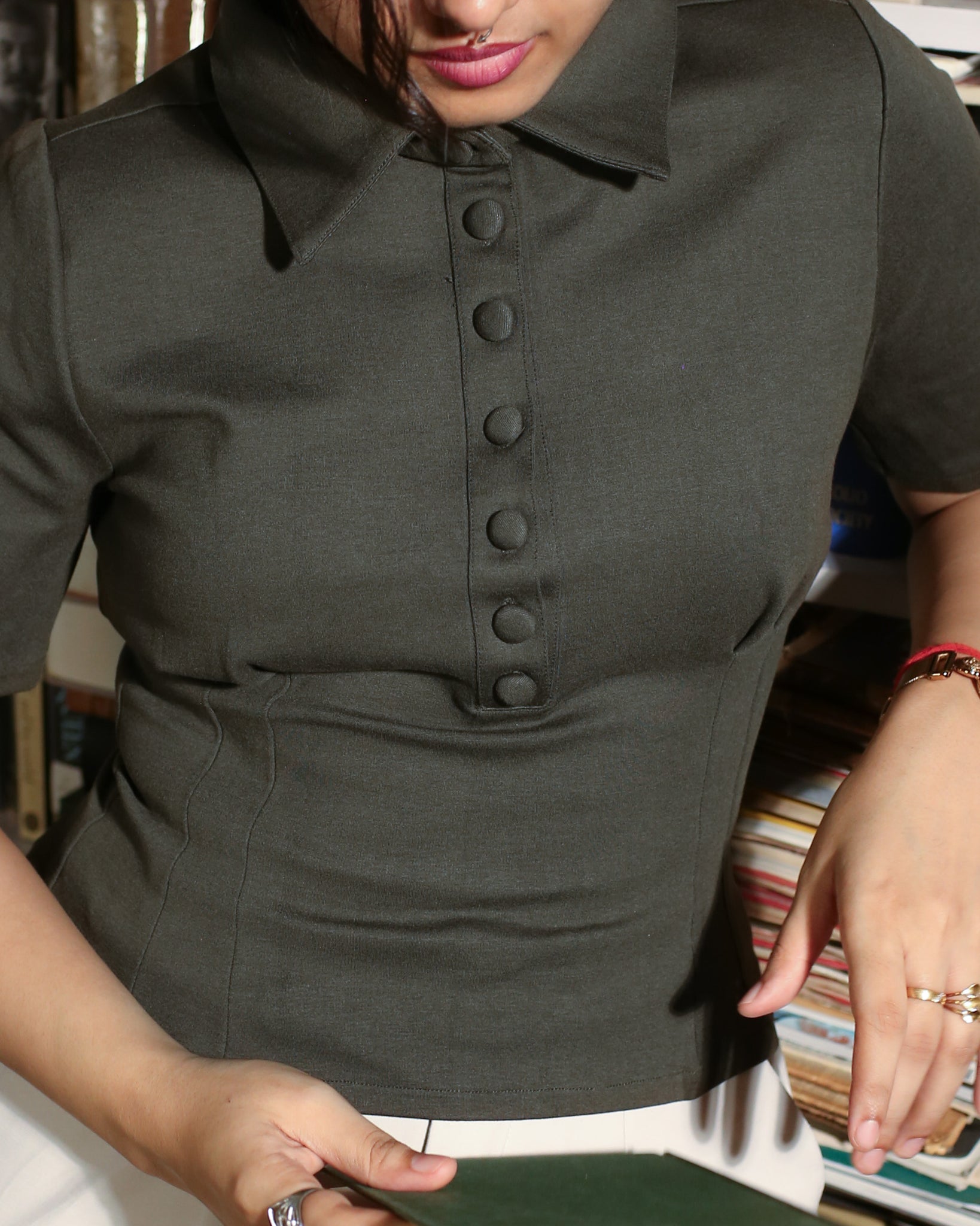 Close-up of dart details on green cotton-stretch polo shirt.