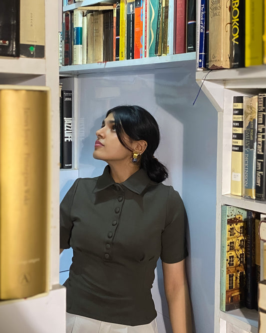 Woman standing in front of a bookshelf filled with books