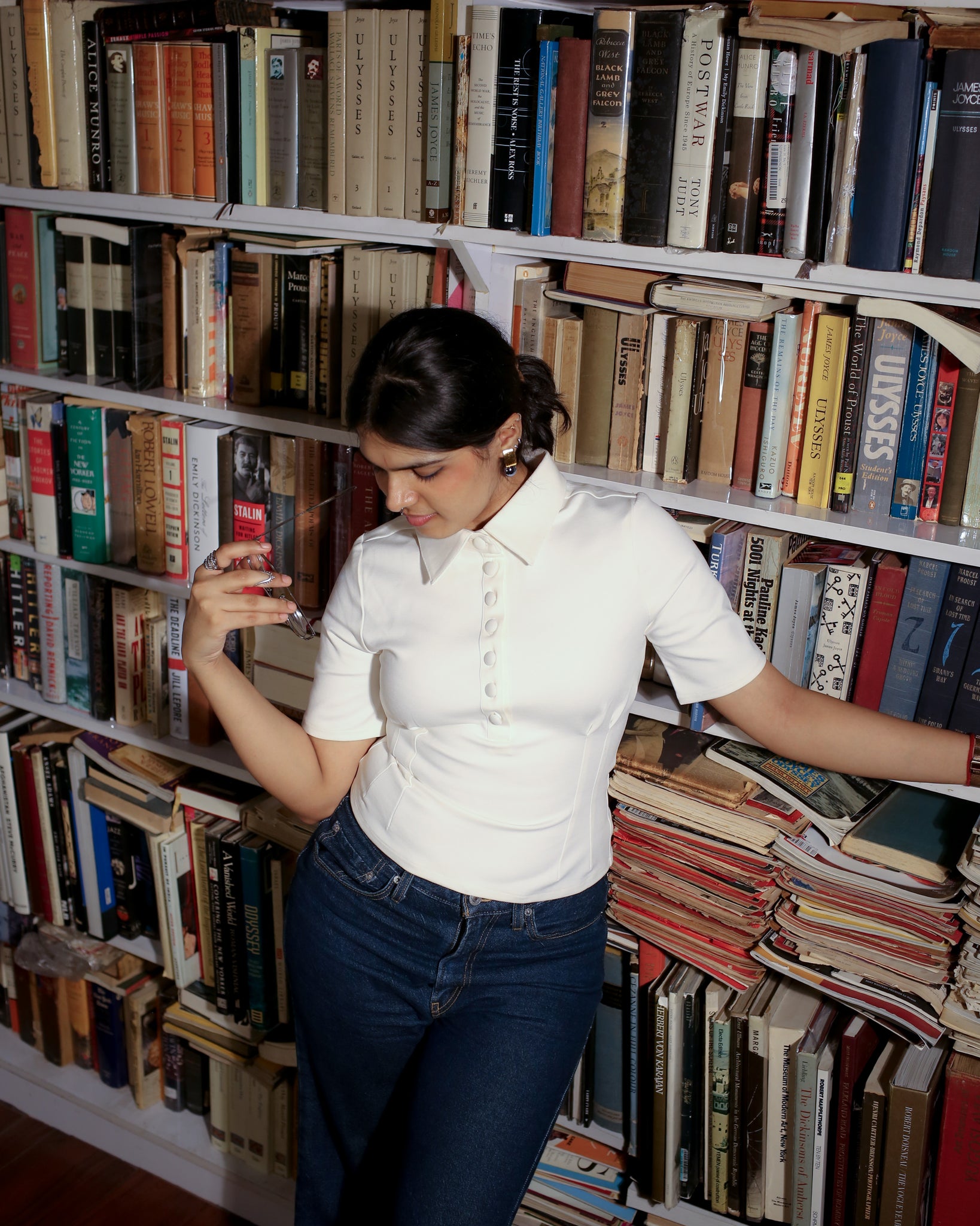 Ivory white polo top worn for a casual workwear look in indoor lighting