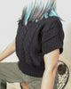 Boxy hand-knitted black wool sweater in 100% pure wool with braided knit detailing on the front.