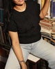 Model styling a black wool sweater in 100% pure wool with jeans for a casual winter look.