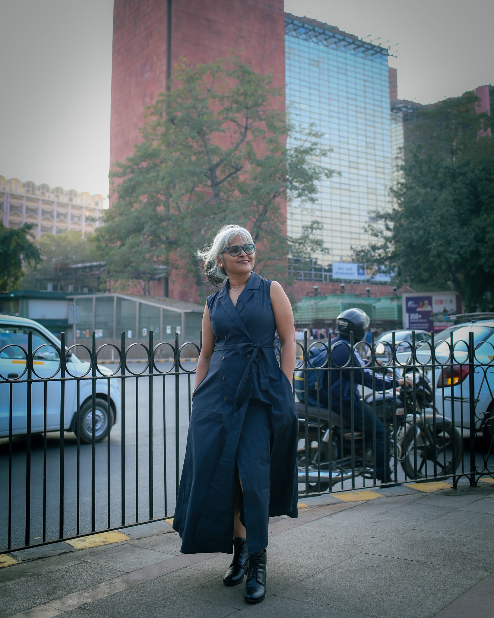 Modern trench‑style wrap dress in midnight blue styled for busy city life