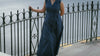 Woman wearing midnight blue belted trench dress with wrap front and A‑line silhouette on city street