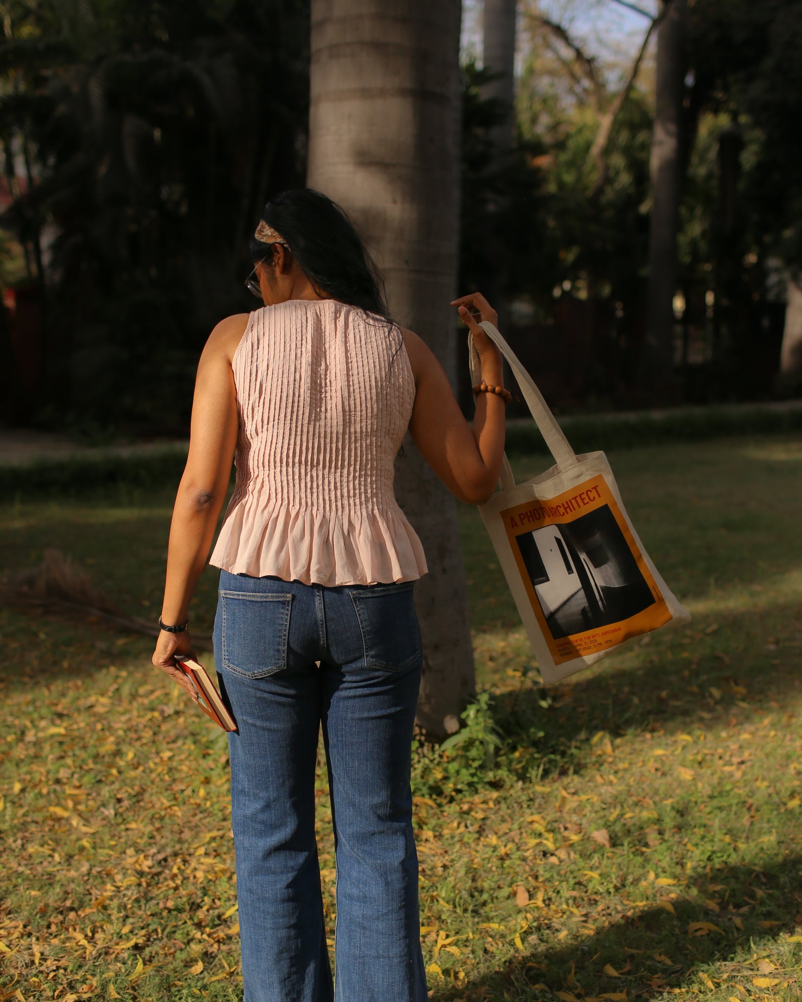 Back view of cotton peplum top with fine pleating from shoulder to waist and relaxed flared hem