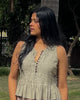 Close front view of sleeveless cotton pleated top with wooden button detailing and soft gathered waist